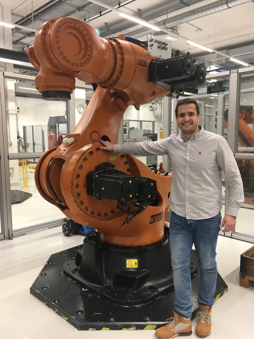 Varga Zsolt egy KUKA ipari robot mellett